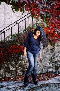 Portrait of a young woman standing on tiled floor