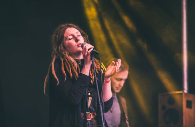 Young woman singing at concert