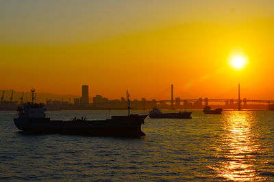 Silhouette ship in sea against sky during sunset