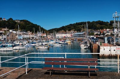 Boats moored in harbor against buildings in city