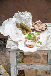 Lard with black bread,pickled cucumber for snack and glass of vodka, still life on peeling old stool