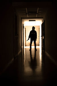 Rear view of man walking in corridor of building