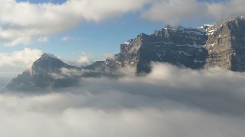 Scenic view of mountains against cloudy sky