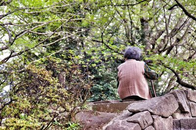 Low angle view of old women sitting on stone wall