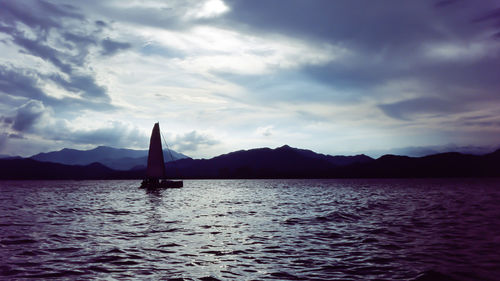 Sailboat sailing on sea against sky