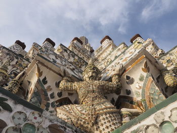 Low angle view of statues on building against sky