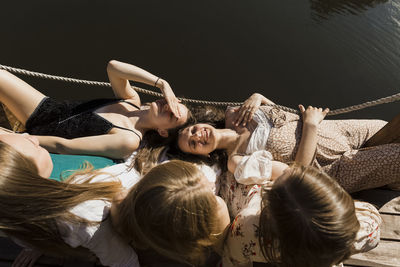 Smiling young women lying on friends lap