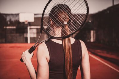 Rear view of woman holding umbrella