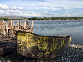 Abandoned boat on sea against sky