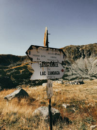 Information sign on field against clear sky