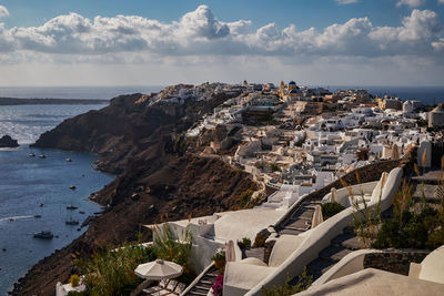 High angle view of townscape by sea against sky