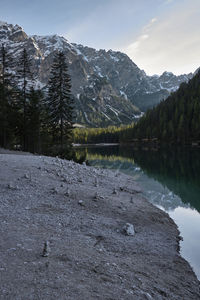 Scenic view of lake by snowcapped mountains against sky