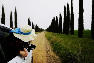 Rear view of woman walking on road against sky