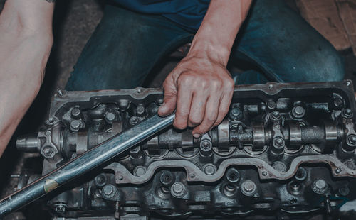 Midsection of man repairing machinery