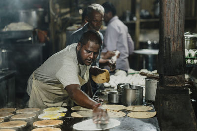 Midsection of man preparing food in kitchen