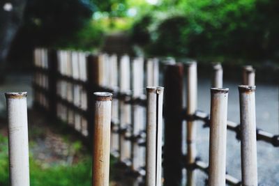 Close-up of wooden post against fence