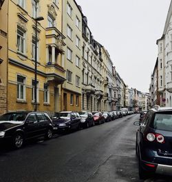 Cars parked on road along buildings