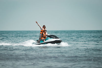 People in boat on sea against sky