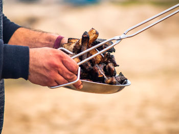 Close-up of man preparing food on barbecue grill