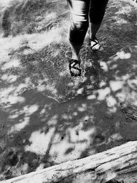 Low section of woman walking on puddle