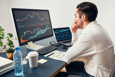 Worried businessman looking at charts stressed by news from stock market. investor lost money online