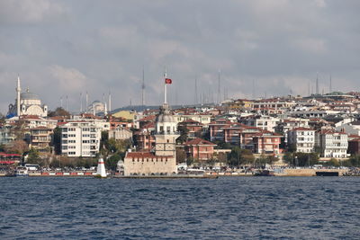 Buildings by sea against sky