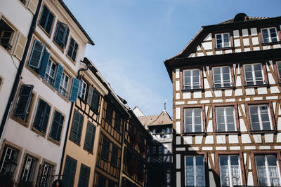 Low angle view of buildings in town against sky