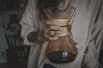 Woman holding carafe with coffee