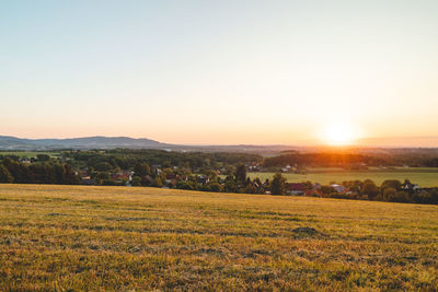 Scenic view of field against clear sky during sunset