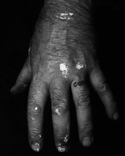 Close-up of human hand against black background