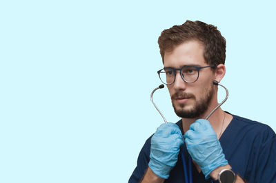 Portrait of young man against blue background