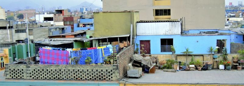 Clothes drying on clothesline in city against sky