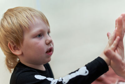 Close-up of cute boy gesturing against sky