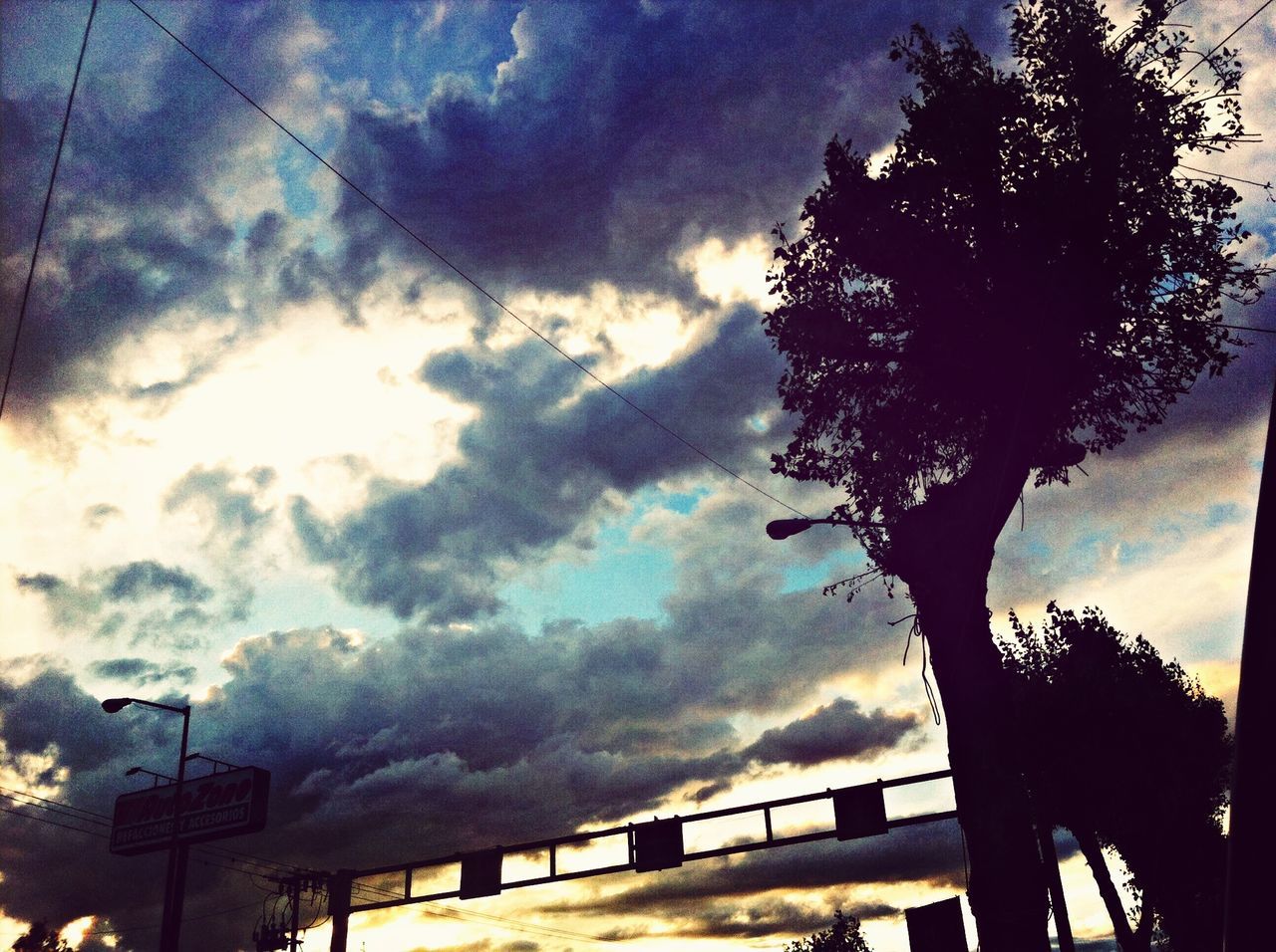 sky, cloud - sky, cloudy, silhouette, low angle view, tree, cloud, weather, railing, dusk, nature, connection, tranquility, overcast, built structure, beauty in nature, fence, scenics, street light, no people