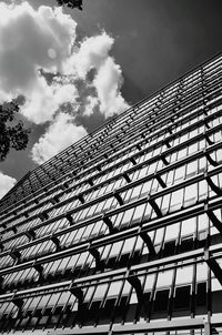 Low angle view of modern building against cloudy sky