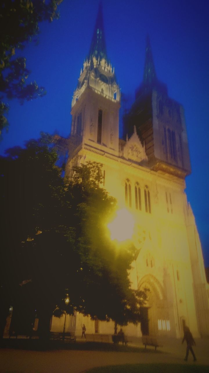 LOW ANGLE VIEW OF ILLUMINATED BUILDINGS AT NIGHT