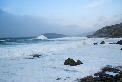 Waves breaking against the rocks of the coast of galicia forming foam