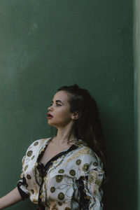  young woman standing against wall