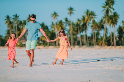 Rear view of people walking on beach