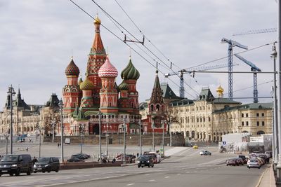 View of city street against cloudy sky