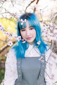 Portrait of young woman standing against plants