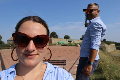 Portrait of couple wearing sunglasses against sky