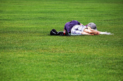 Man and woman sleeping on grassy field