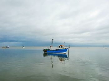 Boat moored on sea against sky