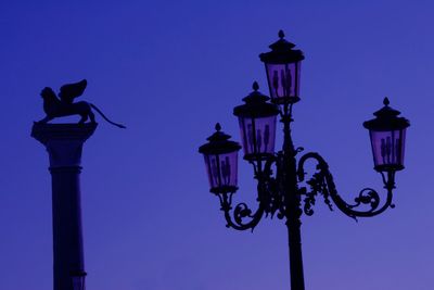 Low angle view of street light against blue sky