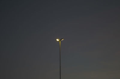 Low angle view of illuminated street light against clear sky