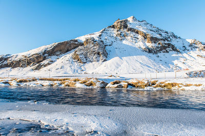 Scenic view of snowcapped mountains against clear blue sky