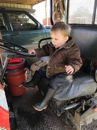 Full length of cute baby boy sitting in vehicle