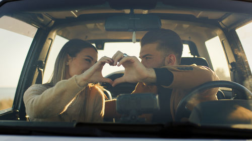 Happy boy and girl in the off road car during valentines day