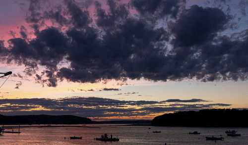 Scenic view of sea against dramatic sky during sunset